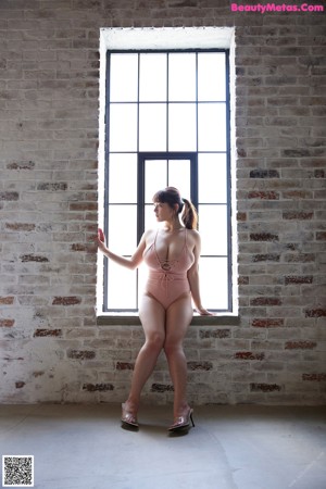 A woman in a pink bathing suit laying on the floor.