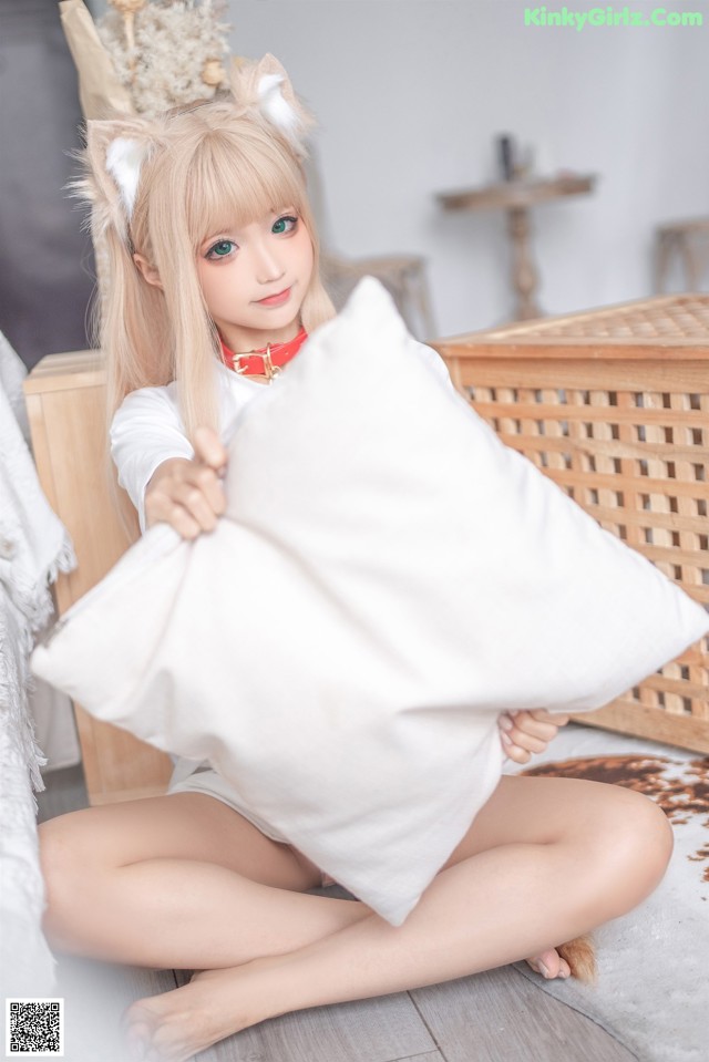 A woman sitting on the floor holding a pillow.