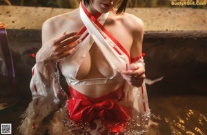 A woman in a red and white outfit is standing in the water.