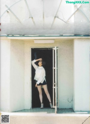 A woman sitting on top of a black chair in a room.