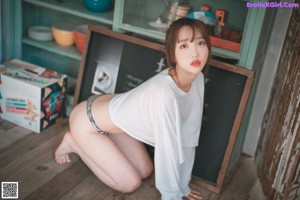 A woman sitting on top of a kitchen counter next to a sink.