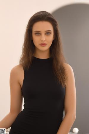 A woman in a pink blouse and black skirt posing for a picture.