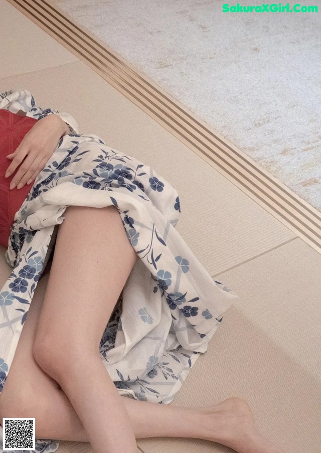 A woman laying on the floor with her legs crossed.
