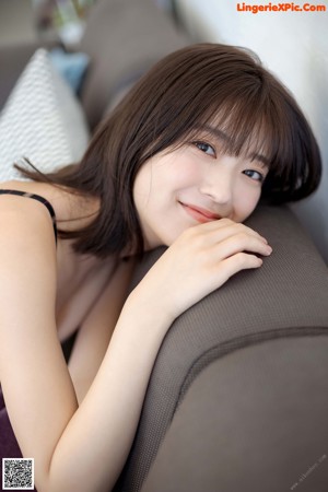 A woman in a bikini standing in front of a couch.