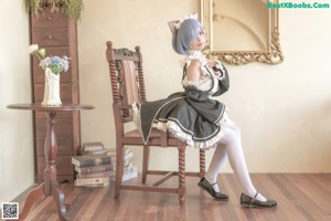 A woman dressed in a maid outfit posing for a picture.