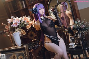 A woman in a black lingerie posing in front of a mirror.