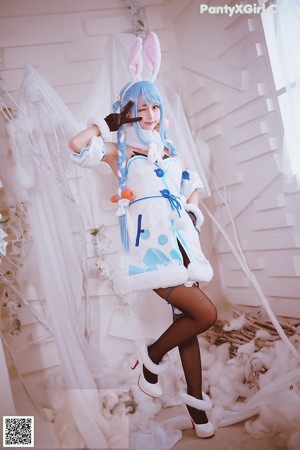 A woman dressed in a maid outfit holding a tray of food.