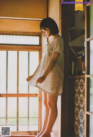 A woman in a white shirt and black skirt sitting on a tatami mat.