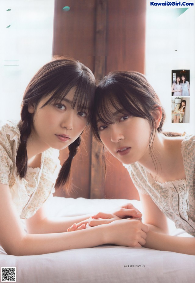 A couple of young women laying on top of a bed.