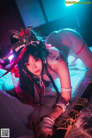 A woman in a white lingerie is posing on a bed.