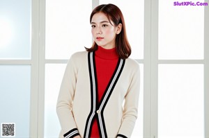 A woman in a red sweater and plaid skirt posing for a picture.