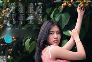 A woman in a pink dress holding a bunch of fruit.