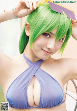 A woman with green hair sitting at a desk.