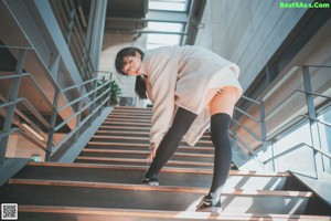 A woman standing on a set of stairs in a building.