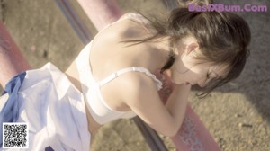 A woman laying on top of a building with a city in the background.