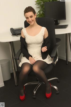 A woman in a black sheer top and black pants posing for the camera.