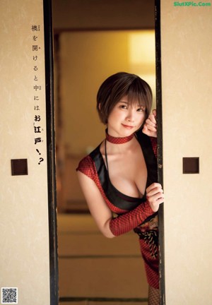 A woman in a kimono is holding a chopstick.