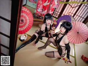 A couple of women sitting next to each other on the floor.