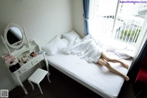 A woman in a pink bra and panties posing on a bed.